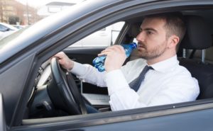 Kierowca pijący wodę w samochodzie